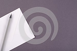 Paper envelope with pencil composition on dark background