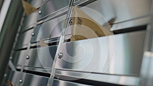 Paper envelopes stuck mailbox closeup. Silver post lockers in building corridor