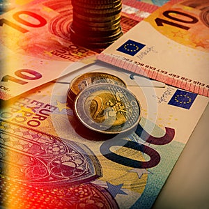 Paper euro banknotes and coins. The coin is two euros. photo