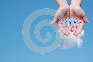 Paper family in hands on blue sky background welfare concept