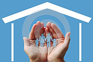 Paper family in hands with home on blue background welfare concept