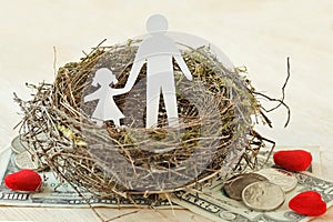 Paper father and daughter in nest on money and hearts - Concept of single parent family