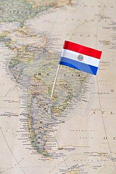 Paraguay flag pin on a world map