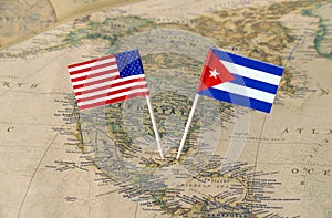 The United States of America and Cuba flag pins on a world map, political relations concept