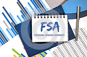 Paper with Flexible Spending Account FSA on a table with charts and pen