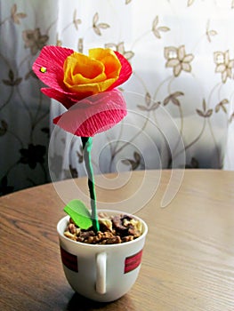 Paper flower in cup on the table