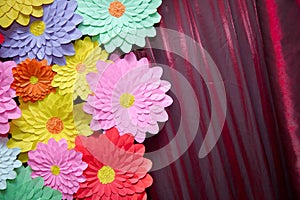 Paper flower. Glade of multi-colored flowers. Red curtain background . Valentine`s Day. Flowers of paper craft colorful backgroun