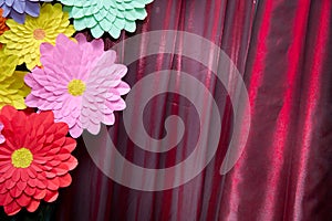 Paper flower. Glade of multi-colored flowers. Red curtain background . Valentine`s Day. Flowers of paper craft colorful backgroun