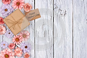 Paper flowers side border with Mother`s Day gift and tag over wood