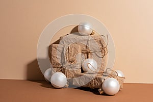 The paper gift boxes with white christmas balls isolated on beige background. Rope on the gift boxes. Idea for decoration presents