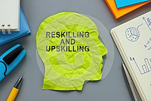 A paper head with inscription Reskilling and upskilling. photo