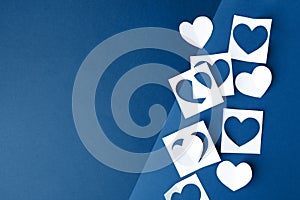 Paper hearts on classic blue background. Empty place for copy space for text. mock-up, minimal concept of romance winter february