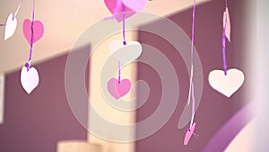 Paper hearts dangle on ribbons, Valentine`s day, indoors