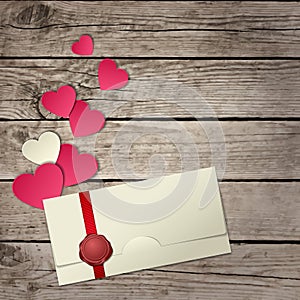 Paper hearts and envelope on wooden