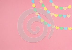 Paper hearts of pastel tones on a pink background