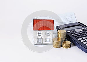 Paper house with coins stack with calculator and saving passbook