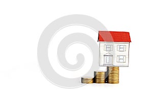 Paper house on coins stack on white background