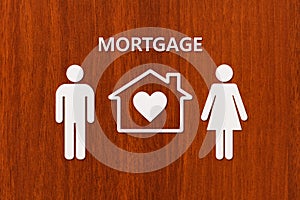 Paper house and family with mortgage text. Conceptual image