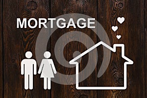 Paper house and family with mortgage text. Conceptual image