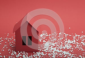 Paper house in snow on red background