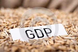 Paper with inscription GDP on oat grain