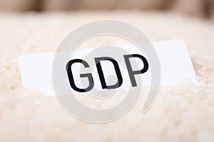 Paper with inscription GDP on rice