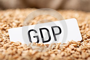 Paper with inscription GDP on wheat grain