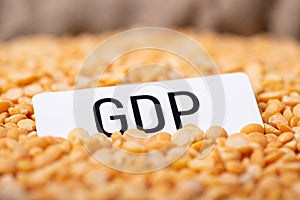 Paper with inscription GDP on yellow pea