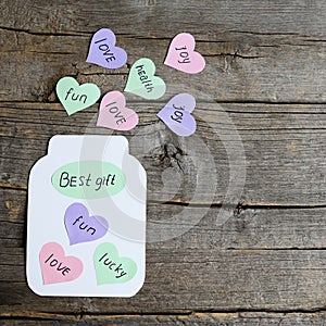 Paper jar with hearts and text Best gift. Colored paper hearts with wishes. Greeting card made of colored paper and cardboard