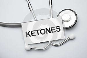 Paper with ketones on a table and grey stethoscope