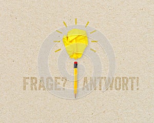 Paper light bulb and pencil with the german words for question and answer - frage und antwort on brown recycled paper background