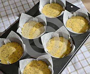 Paper Lined Muffin Tin Filled With Cake Batter.