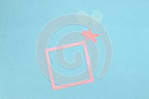 paper man flying with paper balloons and holding pink frame as copy space on pastel blue background