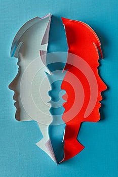 Paper man and woman face profiles cut out of paper on blue background. Bock cover illustration. Man and woman equity concept.