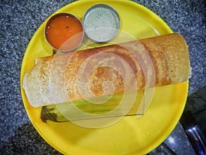 Paper Masala dosa is a South Indian meal served with sambhar and coconut chutney over fresh banana leaf.