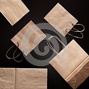 Paper merchandise bags on black background, flatlay