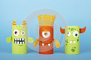 Paper monsters on a blue background. Handmade concept, creative idea from toilet tube