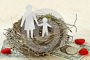 Paper mother and son in nest on money and hearts - Concept of single parent family photo