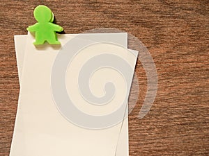 Paper note with green clip on wood background