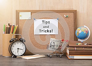Paper note with tips and tricks word on cork board with alarm
