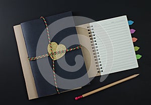 paper notebook pencils on black background