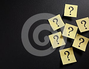 Paper notes with question marks on black background, flat lay. Space for text