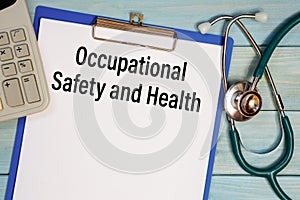 Paper with Occupational Safety and Health on a table, stethoscope and calculator