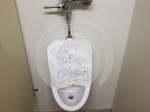 Paper out of order sign on bathroom urinal