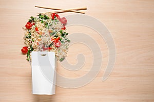 Paper package with delicious food on wooden background