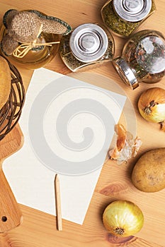 Paper, pencil, jug of olive oil, potatoes, onion