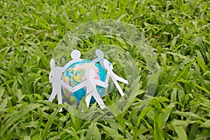 Paper people in a circle with green grass background