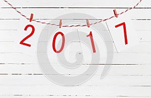 Paper or photo frames with 2017 figures hanging on the red striped rope . New Year design. On wooden background.