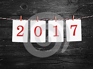 Paper or photo frames with 2017 figures hanging on the red striped rope . New Year design. On wooden background.