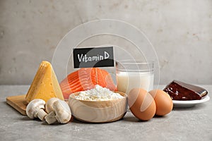 Paper with phrase VITAMIN D and fresh products on table